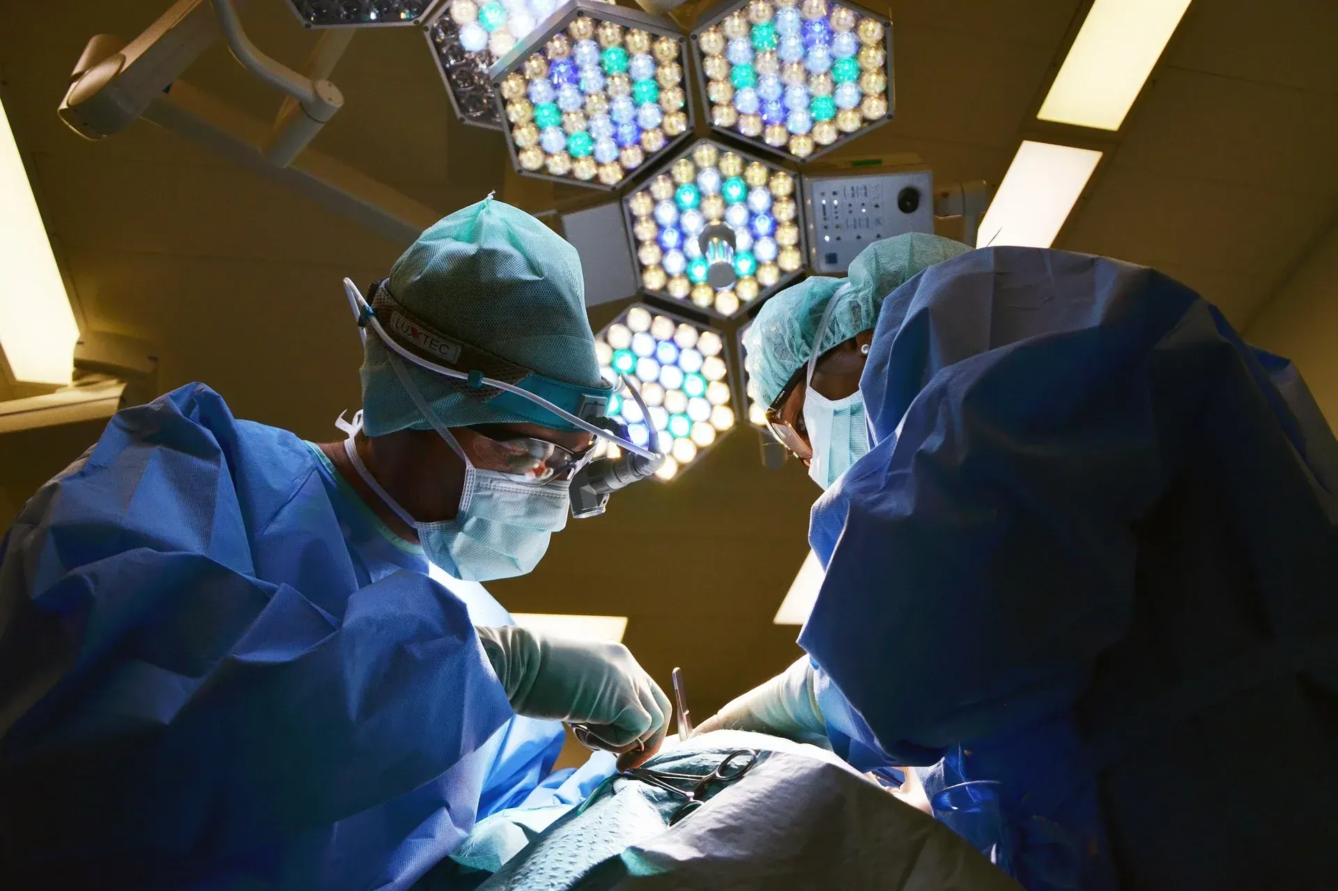 Surgical team operating under theatre lights